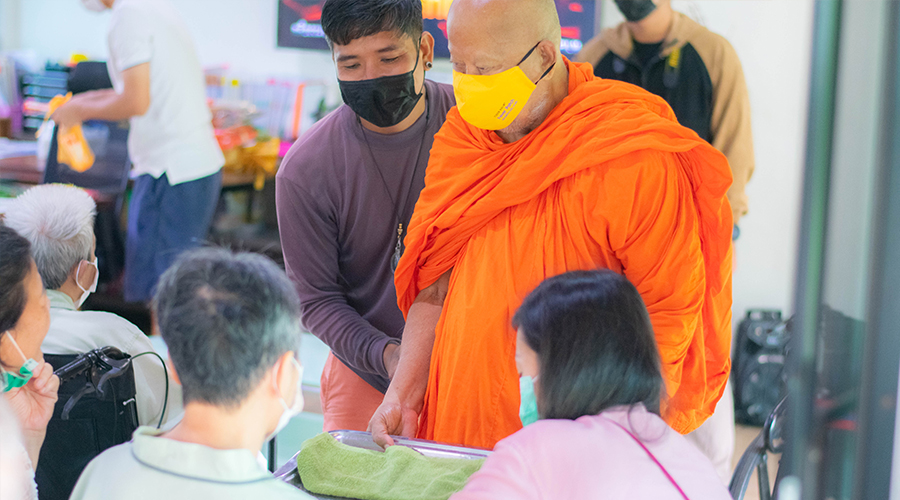 ผู้สูงอายุและบุคลากรทำบุญร่วมกันในวันออกพรรษาเพื่อความเป็นสิริมงคล 
